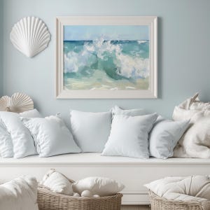 a painting of a wave is hanging above a white couch