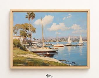 May include: A framed landscape painting depicting a coastal scene with several sailboats moored in calm blue water. The foreground features a grassy shoreline with tall palm trees and a white building, while distant hills are visible under a blue sky.