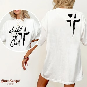 Op de afbeelding: Wit T-shirt met de tekst "child of God" en een kruis op de voorkant. De achterkant van het shirt heeft een kruis met een hart erop.