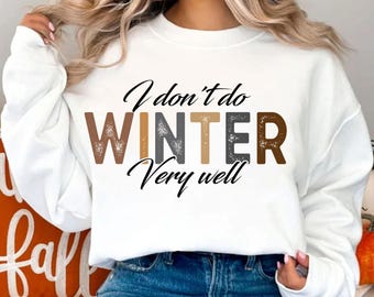 Puede incluir: Sudadera blanca con un estampado gráfico que dice "No hago el invierno muy bien". El texto está en letras marrones, grises y beige con un aspecto desgastado.