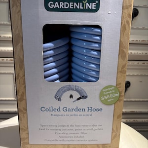 May include: A GARDENLINE boxed coiled garden hose. The light blue hose extends to 10m. The box features the text "Coiled Garden Hose" and "Manguera de jardín en espiral".