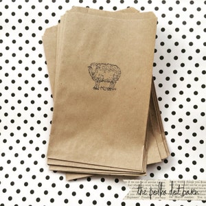 May include: A stack of brown paper bags with a black and white illustration of a sheep on the front of the top bag.