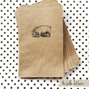 May include: A stack of brown paper bags with a black and white illustration of a pig on the front. The bags are on a white background with black polka dots.