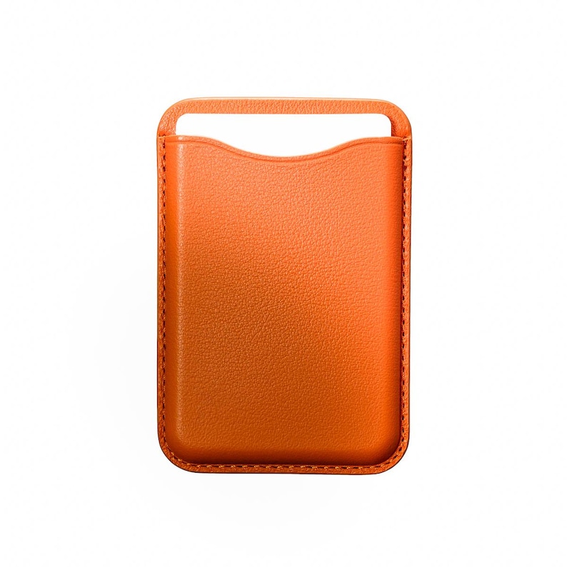 May include: Orange leather phone sleeve with a handle at the top. The sleeve has a rectangular shape with rounded corners and a textured surface. The edges are stitched with a contrasting thread.