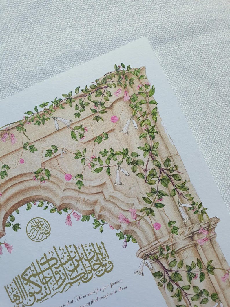 May include: A print featuring an architectural stone archway adorned with climbing green vines and small pink and white flowers. Gold Arabic calligraphy is centered below the arch, accompanied by the English text: 'is that He created for you spouses so that you may find comfort in them'.