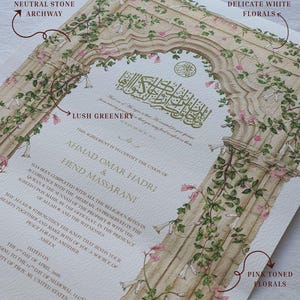 May include: A wedding certificate featuring a neutral stone archway illustration adorned with lush greenery, overgrown vines, and delicate white and pink florals. The document includes gold Arabic calligraphy, English text, and the names Ahmad Omar Hadri and Hend Massarani.