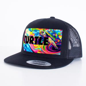 Könnte beinhalten: Schwarze Trucker-Kappe mit einem bunten Grafikdruck einer Meeresschildkröte, die in einem Strudel aus Farben schwimmt. Das Wort "TURTLE" ist in schwarzen Buchstaben über dem Grafikdruck gedruckt.