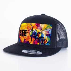 May include: Black trucker hat with a colorful bee graphic and the word "BEE" in black text.