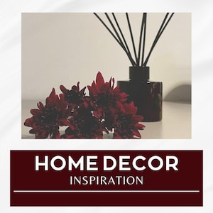 Puede incluir: Imagen de decoración del hogar con un difusor de caña rojo oscuro y un ramo de flores rojo oscuro. El difusor está en una botella cuadrada marrón oscuro con cañas negras. El texto "HOME DECOR INSPIRATION" se muestra en blanco sobre un fondo rojo oscuro.