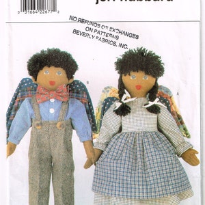 May include: A sewing pattern for two dolls, a boy and a girl, with angel wings. The boy doll is wearing a blue and white striped shirt, brown pants, and a red bow tie. The girl doll is wearing a blue and white plaid dress. The pattern is titled "4279 Butterick" and "jeri hubbard".