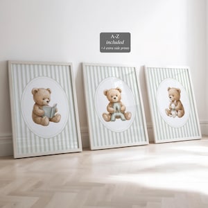 May include: Three framed prints featuring watercolor illustrations of teddy bears. Each print has a white frame and a background with vertical stripes in light green and white. The teddy bears are depicted in different poses, holding a book, a letter, and a stuffed animal.