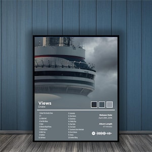 May include: A framed poster featuring the album "Views" by Drake. The artwork showcases a portion of a tall building against a cloudy sky. The poster includes the album's tracklist, release date, and album length.