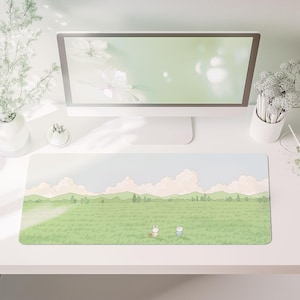 Può includere: Tappetino per scrivania rettangolare con un paesaggio a cartoni animati. Raffigura un campo verde, cielo blu e nuvole, con due personaggi dei cartoni animati. Il tappetino è su una scrivania bianca, insieme a un monitor e oggetti decorativi.