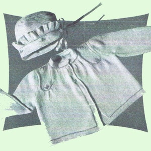 May include: A light-colored knitted baby outfit, including a bonnet with a ruffled brim and a button-down jacket. The jacket has short sleeves and decorative stitching around the collar and shoulders. The set is displayed against a dark background.