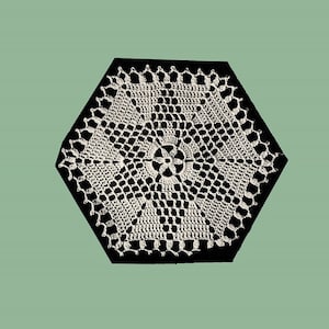 Puede incluir: Doily de ganchillo blanco con forma hexagonal y un delicado diseño floral en el centro.