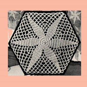 以下が含まれることがあります： 中心に星形のデザインが施された、六角形の白いクロシェのドイリーです。