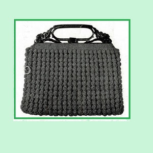 May include: A black crocheted handbag with a black plastic handle. The bag has a textured, bumpy surface.