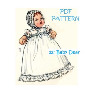 May include: A PDF pattern for a 12" Baby Dear doll dress. The dress is white with a lace trim and the doll is wearing a white bonnet.