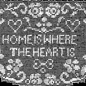 Op de afbeelding: Wit gehaakt rechthoekig stuk met de tekst "HOME IS WHERE THE HEART IS". Het gehaakte stuk heeft een delicaat, open ontwerp met bloemen en geometrische patronen en een geschulpte rand.