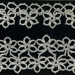 May include: White crocheted lace trim with a repeating pattern of flowers. The lace is on a black background.