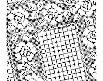 May include: Black and white image of a crocheted tablecloth with a floral design. The tablecloth is laid over a table with a decorative centerpiece.