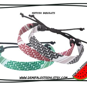 May include: Three adjustable Keffiyeh bracelets in red, black, and green patterns. The bracelets have black cords and are displayed on a white background. The text "KEFFIYEH BRACELETS" is at the top.