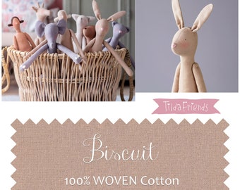 May include: A basket filled with various handmade fabric dolls, including a rabbit, elephant, and giraffe. The dolls are made from a beige fabric called "Biscuit" which is 100% woven cotton and non-stretch. The fabric is ideal for doll making.