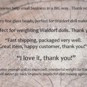 May include: Reviews on a wooden surface with the text "Reviews help small business in a BIG way. Thank you!!" and several customer reviews about glass beads, including "Very fine glass beads, perfect for Waldorf doll making.", "Perfect for weighting Waldorf dolls. Thank you!" and "I love it, thank you!"