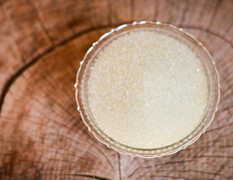 May include: A clear glass bowl filled with white sugar crystals.
