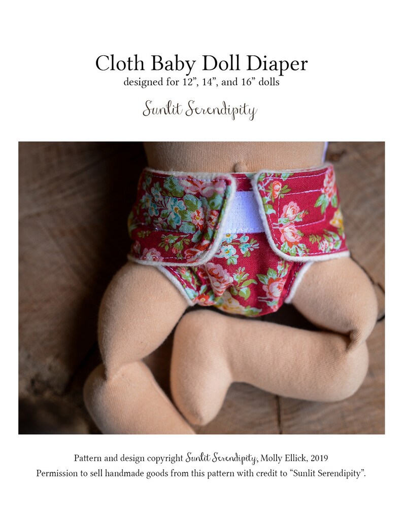May include: A cloth baby doll diaper with a floral pattern in red, pink, and green. The diaper is designed for 12", 14", and 16" dolls. The text "Cloth Baby Doll Diaper" and "Sunlit Serendipity" are visible.