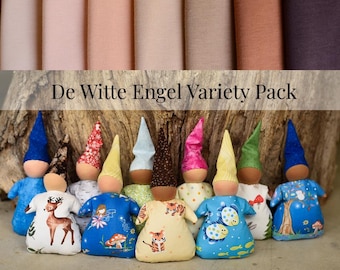 May include: A collection of ten small fabric dolls with pointed hats and round wooden heads, arranged in a row. The dolls feature various patterns including deer, tigers, fish, and mushrooms. The text 'De Witte Engel Variety Pack' is visible.
