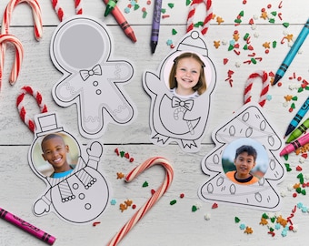 May include: Christmas-themed photo ornaments in the shape of a gingerbread man, penguin, snowman, and Christmas tree. Each ornament has a circular space for a photo. Candy canes and crayons are scattered around the ornaments.