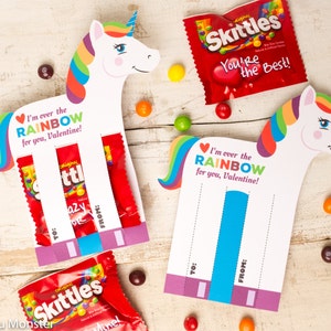 Könnte beinhalten: Eine druckbare Valentinstagskarte mit einem Einhorn mit einer Regenbogenmähne und einem Regenbogen-Schwanz. Die Karte hat einen Schlitz, um eine kleine Tüte Skittles-Süßigkeiten zu halten. Der Text auf der Karte lautet "Ich bin über dem REGENBOGEN für dich, Valentinstag!"