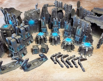 May include: A collection of miniature sci-fi terrain pieces featuring dark gray, weathered stone-like structures with glowing cyan energy cores and accents. The set includes ruined walls, towers, small cylindrical power nodes, and debris.
