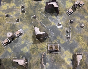 May include: A tabletop wargaming mat featuring a mottled green and brown camouflage pattern with various miniature terrain pieces, including ruined stone walls, industrial water towers, and rectangular crates, all outlined with white borders.