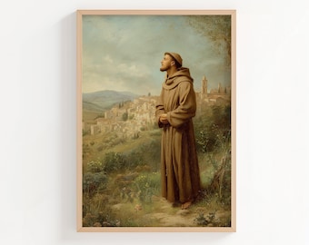 May include: A framed print of a religious figure in a brown robe, standing in a field and looking towards a distant town. The artwork has a classical painting style with a soft color palette of greens, browns, and blues.