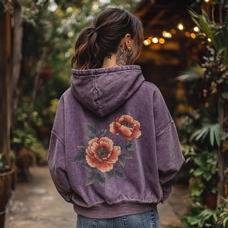 May include: A purple hooded sweatshirt with a floral design on the back. The flowers are red, orange, and green.