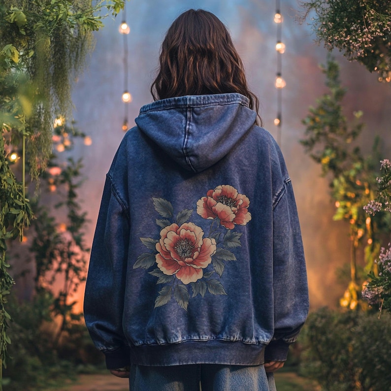 May include: A blue denim hoodie with a floral design on the back. The flowers are red, orange, and yellow.