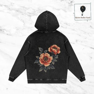 May include: Black hooded sweatshirt with a vintage wash and a floral design on the back. The flowers are red, orange, and green.