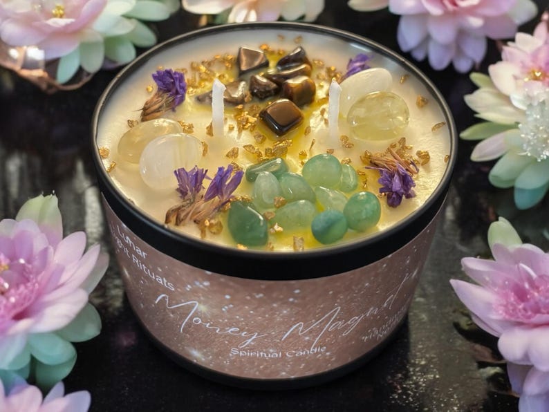 May include: A white candle with gold glitter and various crystals embedded in the wax. The candle is in a black jar with a gold label that reads "Money Magnet Spiritual Candle".