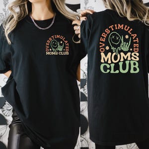 a woman wearing a mom's club t - shirt