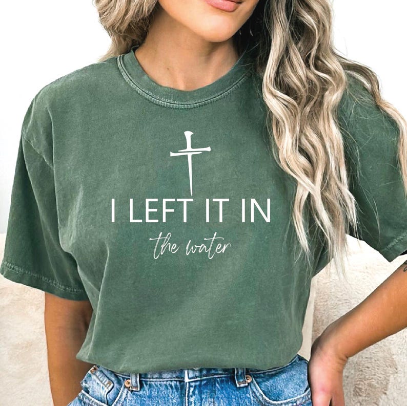 A woman wearing a green t-shirt with the text "I LEFT IT IN THE WATER" printed on it.