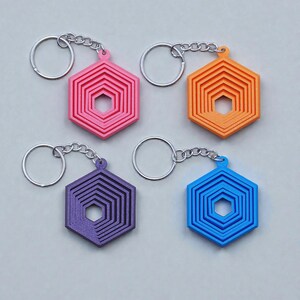 Handmade and customizable hex fidget keychains shown in assorted colors, featuring colorful designs, perfect for kids birthday parties, classroom prizes, sensory play, and party favor gifts.