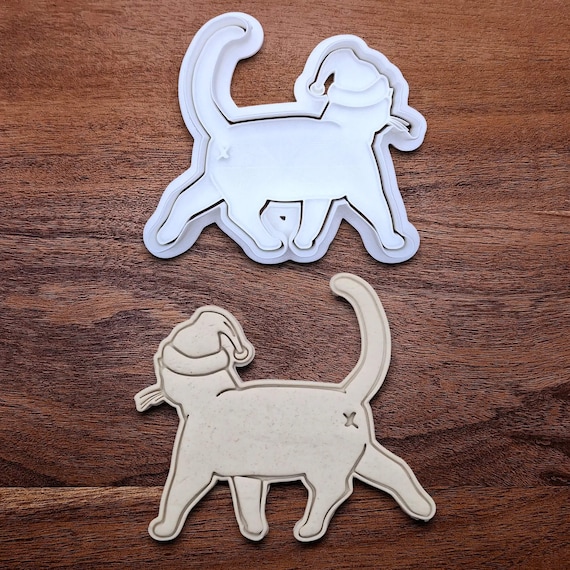 A cat butt cookie cutter shaped like a Santa-hatted feline rear — handmade in the USA, and the resulting cookies will absolutely derail any holiday party.