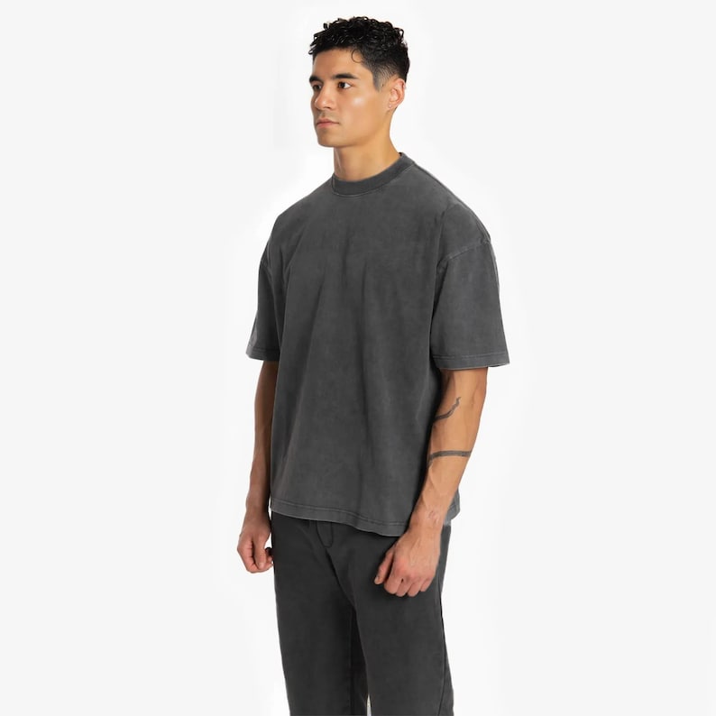 May include: A dark gray, oversized t-shirt with a relaxed fit and short sleeves.