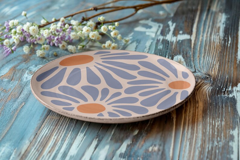 May include: A ceramic plate with a floral design. The plate is pink with purple and orange flowers.