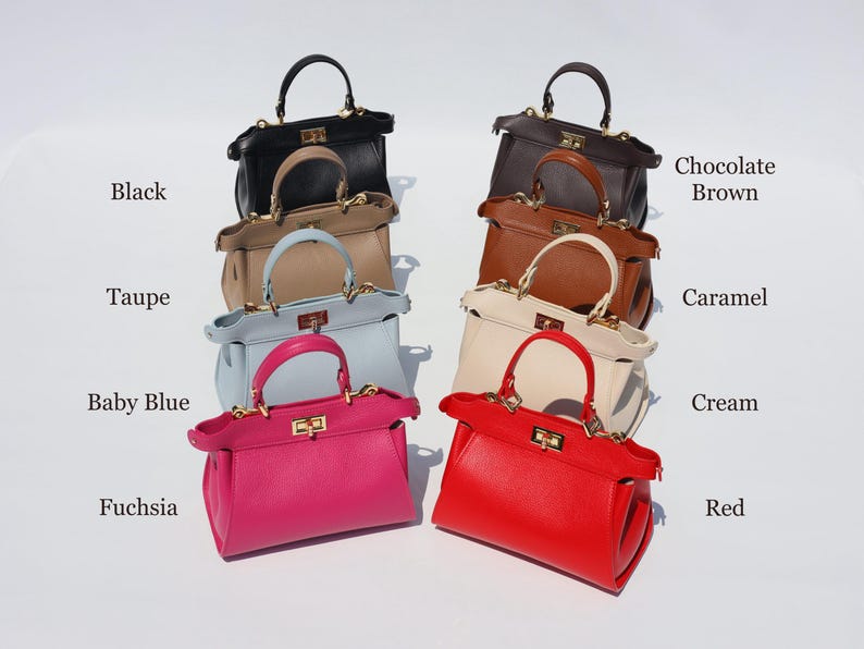 K&ouml;nnte beinhalten: Eine Sammlung von zehn Ledertaschen in verschiedenen Farben, darunter Schwarz, Taupe, Babyblau, Fuchsia, Rot, Creme, Karamell, Schokoladenbraun. Jede Tasche hat einen goldenen Verschluss und einen oberen Griff.
