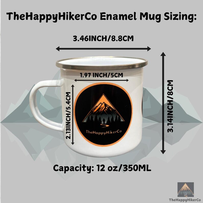May include: White enamel mug with a black and orange mountain design and the text "The Happy HikerCo". The mug is 8.8 cm wide, 5.4 cm tall, and 8 cm deep. It has a capacity of 350 ml.