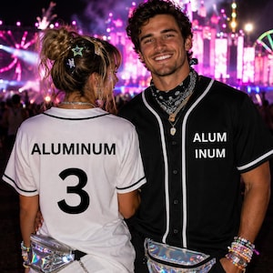 May include: A white baseball jersey with the text ALUMINUM and the number 3, and a black baseball jersey with the text ALUM INUM. Both jerseys feature white piping and are paired with iridescent fanny packs worn around the waist.