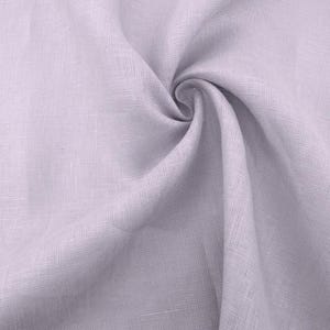 May include: A close-up of a light purple linen fabric with a soft, textured surface.